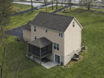 A dark-stained enclosed deck with screens and roof in Strafford, PA